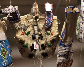 Close up of knife sheath, rattles, vest, guantlets, purses, pouches and belts.