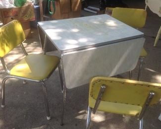 Vintage Formica drop leaf table with three bright yellow chairs. Presale.....$125