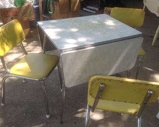 Vintage Formica drop leaf table with three bright yellow chairs.   Presale.....$125