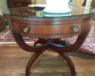 One of a pair of yummy 1940's mahogany round end tables with two drawers each, tooled leather tops and glass protective tops - safe for parties and approved by the Stepford Society of Buckhead.