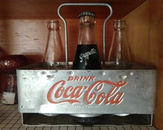 Vintage aluminum Coca-Cola bottle carrier, with "Grapette" bottles