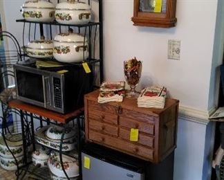 Mini frig with wood cabinet and quartz clock.