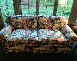 Upholstered couch with floral design.