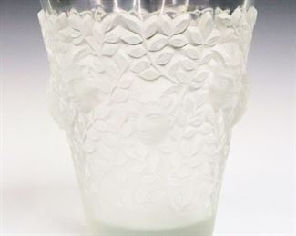 Lot 7: A Lalique Crystal "Silenes" Vase.  Frosted and clear vase with repetitious pattern of Satyr masks and leafy vines.  Acid etched mark "Lalique Cristal  France".  Minor surface scratches, particularly at the underside, small chip at the interior rim.  6 7/8" diameter, 8" high.  