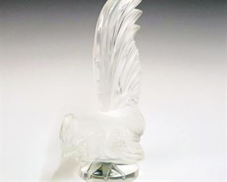 Lot 15: A Lalique Crystal Car Mascot.  Frosted and clear crystal hood ornament in the form of a rooster.  Etched signature "Lalique France" and label at underside.  Minor wear, overall condition is good. 8" high.  