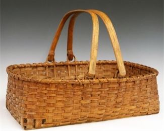 Lot 34: A Turn of the Century American Splint Basket.  Double bent hickory handles and a woven splint body.  Wear and minor damage.  22 1/2" long. 