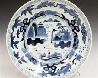 Lot 49: A 20th Century Chinese Bowl.  Blue and white decorated at the front and back, with six character mark at the underside.  Some wear.  18 1/4" diameter.