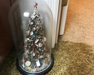 Vintage folk art Christmas tree under glass dome.