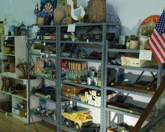 Light Metal Shelving Units (Available Sunday P.M.) with lots of games (Jacks, Pick-up Stix, Cards, Checkers, Chess, Marbles), toys, woodworking tools, an air wrench and various pieces of pottery. Tonka Truck is gone.