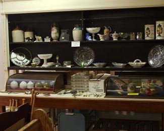Large Table and Display Shelving Unit, 2 Curved Glass Tabletop Display Cabinets, Glass Ornaments for Lightning Rods, Old Ceramic Faucet Handles, numerous pieces of pottery and glassware. Items sold separately