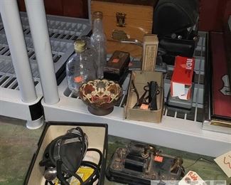 6612: Misc. Vintage bottles, grooming tools, shoe shining box, and more!
Lots of amazing vintage finds in this lot! Shown first is a 1903 Western Electric type 293 wall telephone internal mechanism, a vintage Oster handheld massager, some barber tools, decanters, decorative dish, clippers and heads, shavers, a vintage RCA electronic tube new in box, a combination sewing awl, and a vintage heavy duty stapler, and a Griffin Shinemaster shoe shine box with accessories, and a super vintage black metal flip top lunch box with several hand tools.