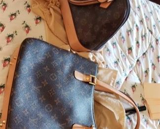 8703:
Not authenticated 2 Louis Vuitton purses
These two handbags shown here have not been authenticated but appear to match the Alma handbag by Louis Vuitton featuring leather hand carry, two-way zipper with padlock, leather key bell, golden color metallic pieces, natural cowhide leather trim, textile lining, interior double smartphone pocket, protective bottom studs.