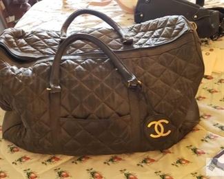 8704: Not Authenticated Chanel bag
The duffel bag shown here is an apparent Chanel designer model (circa 2000’s) though not authenticated but bears a makers label. Crafted from black nylon this bag features dual flat leather handles and a black-tone hardware, zip closure, side zip pocket.