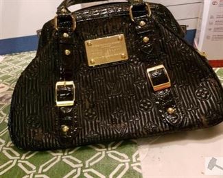 8712:
Louis Vuitton Handbag
This shiny black leather handbag bears the official Louis Vuitton Inventeur seal. This gorgeous textured handbag with gold hardware will be a beautiful accessory to your evening wear.
