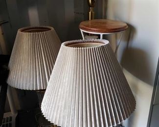 8912: 3 Lamps and Pot Stand
This lot features two crystal and brass lamps with pleated beige shades, a brass, ceramic, and white glass floor lamp, and a white metal plant stand with round wooden top.Tallest lamp measures approximately 4' tall