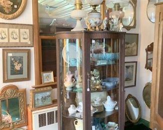 Another curved glass showcase with pottery, Lamps etc.