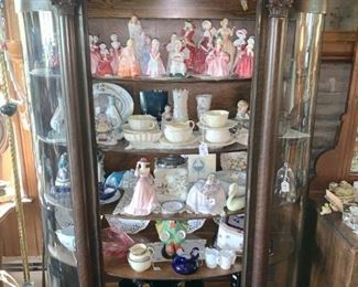 Curved glass showcase (We have 2), filled with figurines and porcelain.)