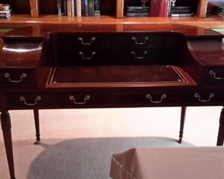 Rare Stunning Sligh Two-Tier English writing desk with leather top writing surface furniture of Holland, Michigan. The brass lock hardware accents the 9 drawers with original brass pulls. The curved back is beautifully finished so the desk can free-stand in a room. Lesser size listing as follows on another site...not same desk but same maker. https://www.1stdibs.com/furniture/tables/desks-writing-tables/sligh-walnut-curved-front-desk-leather-top/id-f_1141858/?gclid=Cj0KCQjwv8nqBRDGARIsAHfR9wCSzbjfRooPw17h1GRU9-mS9jtoJT_NI9xHfYXxVB7voUHKdIeTFxgaAhgsEALw_wcB&gclsrc=aw.ds