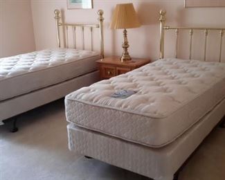 Two sets of twin brass head boards, mattresses, box springs and rails. All in like-new condition.