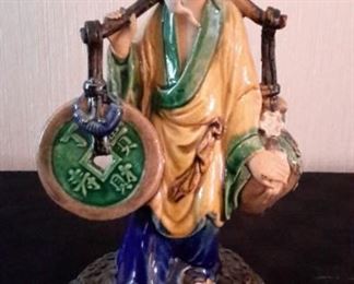 Antique Chinese Mud Man figurine, 10", carrying coin and fruit. Attached via bolt to brass base.