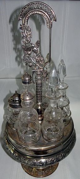 6 Bottle Caster Set In Ornate Silver Frame