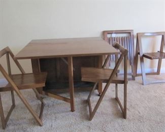 Mid century "hide away"teak drop leaf table with four chairs.  Chairs nestle into table for storage.  Made in Romania - great design 