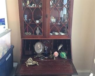 Vintage secretary with various collectibles.