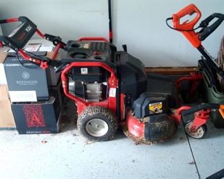 Troy Bilt mower, equipment with accessories including a power washer, snow blower, de-thatcher, and aireator & rack.