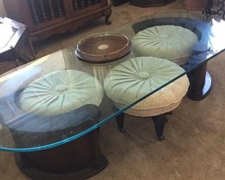 Coffee table with glass top and curved base houses rolling benches, shown all tucked in