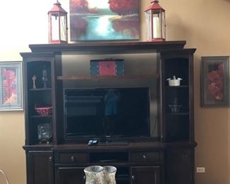 The media unit is actually in four parts - each side of the unit come off (and would look good flanking a fireplace) and the top, or bridge, removes - so you could put quite a large TV on the remaining credenza.  The sides and below are great for storage, video game consoles, audio equipment, etc.  