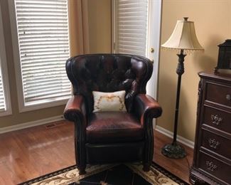 Leather recliner chair with tufted seat back.