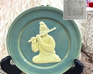 Small Chinese plate man playing flute. Signed on the back.