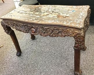 This is an unusual and exceptional Chinese table! Made of exotic hard wood and inlay of mother of pearl and abalone. Carvings on the side are of dragons in the sky. Very old so missing some inlay (39" x 29" x 19"). Estate sale price: $5,000