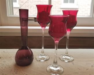 Amethyst bud vase, three red glass candle holders.