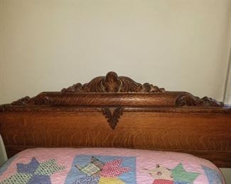 Twin bed with relief carved antique headboard, frame, mattress and box spring.