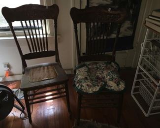 A pair of pressed-back dining chairs
