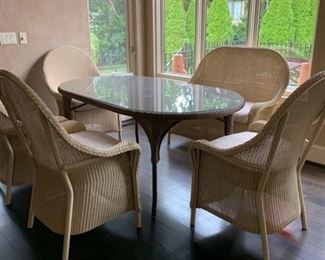 Lloyd Flanders wicker set. Glass top with 4 chairs and bench seat. Table is 40 X 71. The seat cushions were reupholstered last year in a very neutral cream fabric. Synthetic wicker can be used in or outdoors. 