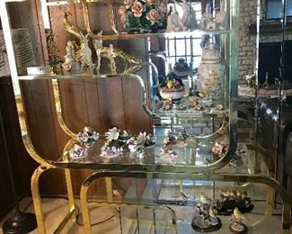 MID-CENTURY MODERN BRASS AND GLASS ETAGERE ATTRIBUTED TO MILO BAUGHMAN , COLLECTION OF CAPO DI MONTE FLOWERS