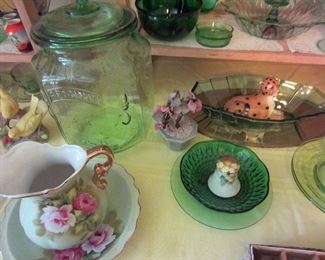 Large green "peanut" canister, smaller pitcher and bowl, one of several glass flower decorations