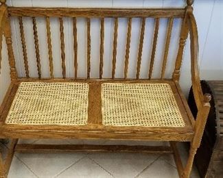Vintage settee with caned seat.