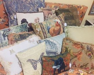 great bed filled with needlepoint and tapestry pillows