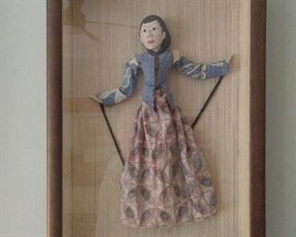 One of a pair of shadowbox framed dolls.
