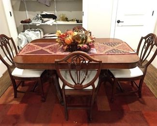 1940's mahogany dining table, with one leaf, original pads and four matching chairs. 
