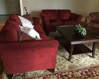 Red sofa and loveseat, hand tufted wool rug.