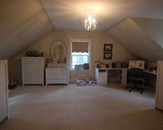 Three white wicker chest of drawers and a wicker dresser with mirror.  Desk with office chair.  