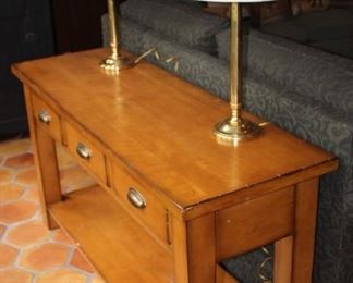 Sofa console shown with brass lamps.  