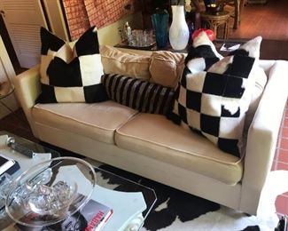 Sleeper sofa and pair of cowhide pillows. 