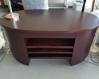 Oval wood desk with lower shelves
