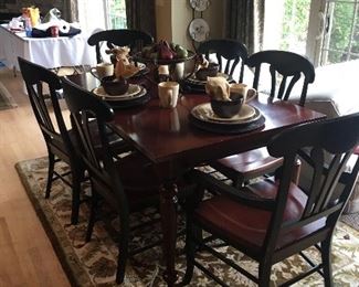 Dining set with one additional leave.  Distressed wood, two tone chairs Black frame with cherry seats.  Two arm and 4 side chairs.  Made in Italy!