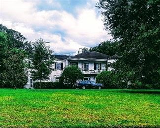 Panoramic beautiful view of front of home with its luscious mature treed landscape 
